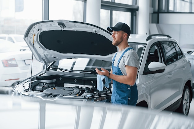 A mechanic performing car repair in an auto service garage.